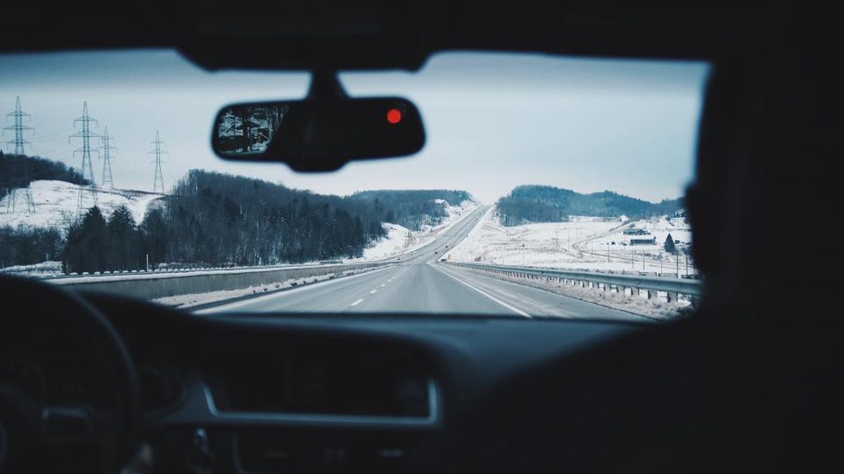 フロントガラス越しに見た、雪景色のなかを続く道